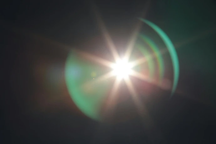 the sun is shining brightly in the dark sky